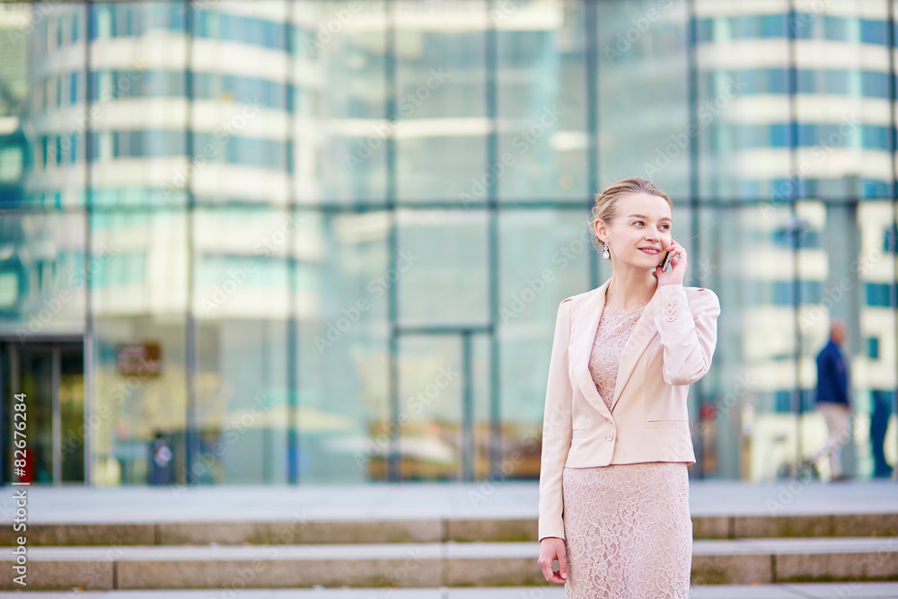 Young confident business woman using phone
