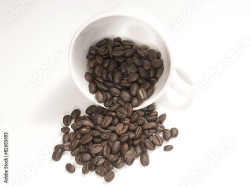 white cup with coffee beans isolated
