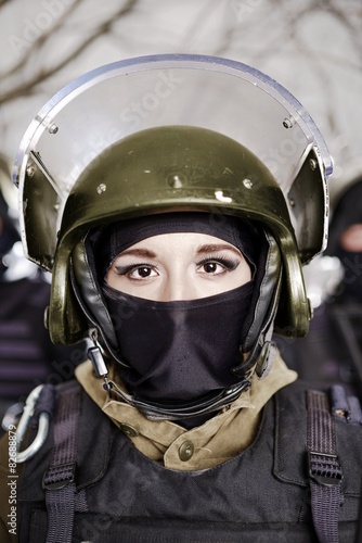 The beautiful young girl in a military uniform and a helmet