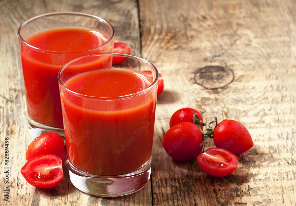 Fresh tomato juice and tomatoes on the table, selective focus Fresh tomato juice and tomatoes on the table, selective focus