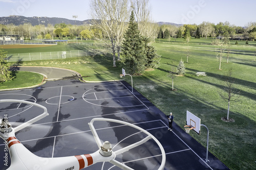 quadcopter drone flying over basketball court