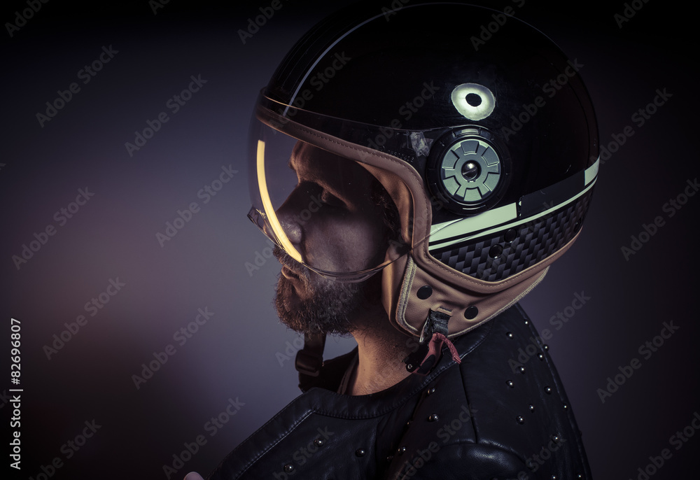 biker with motorcycle helmet and black leather jacket, metal stu