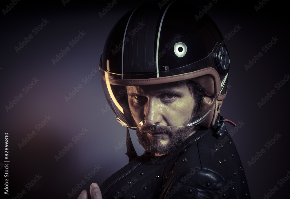 biker with motorcycle helmet and black leather jacket, metal stu