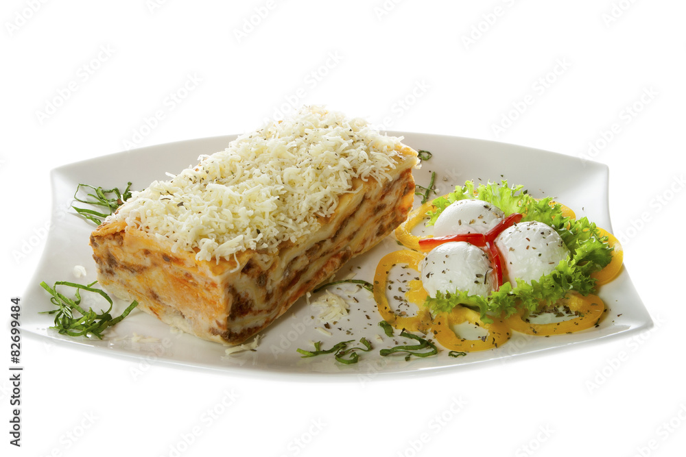 Delicious lasagna on a plate with garnish. Isolated on white. Delicious lasagna on a plate with garnish. Isolated on white.