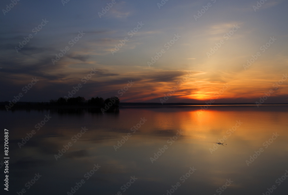 sunset on a river, sun over island on a lake
