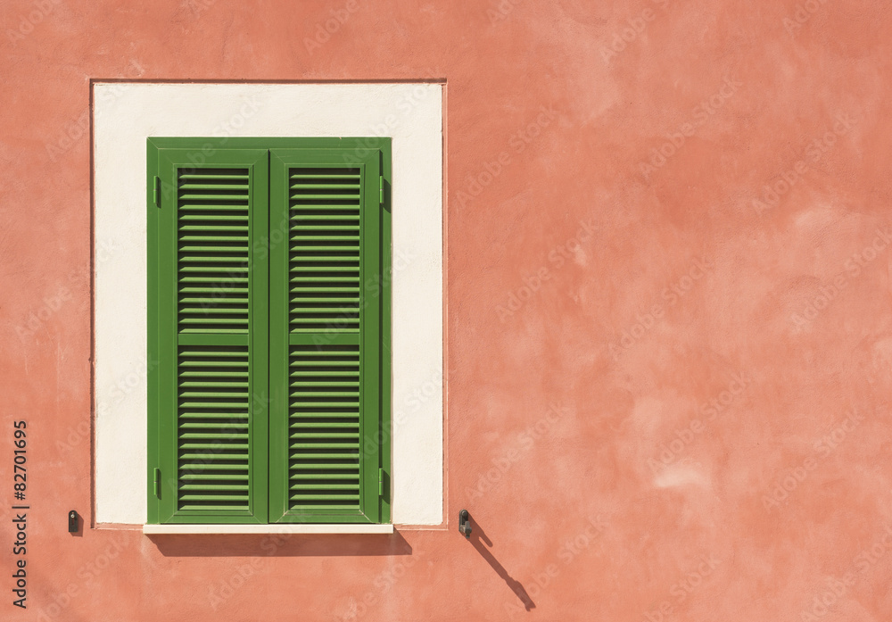 Mediterrane Fassade mit grünem Fenster