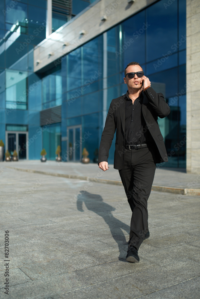 Businessman goes and speaks on phone. Businessman goes and speaks on phone.