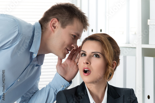 Young man telling gossips to his woman colleague © Liudmila Dutko