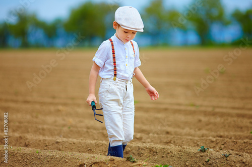 cute farmer boy walking the arable field