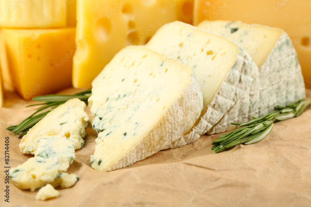 Various types of cheese with rosemary on table close up