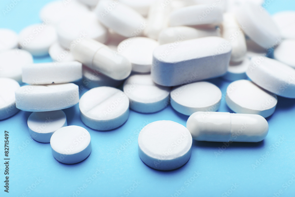 Pile of pills on color table, closeup Pile of pills on color table, closeup