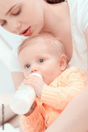 Mother and her little baby with the bottle 