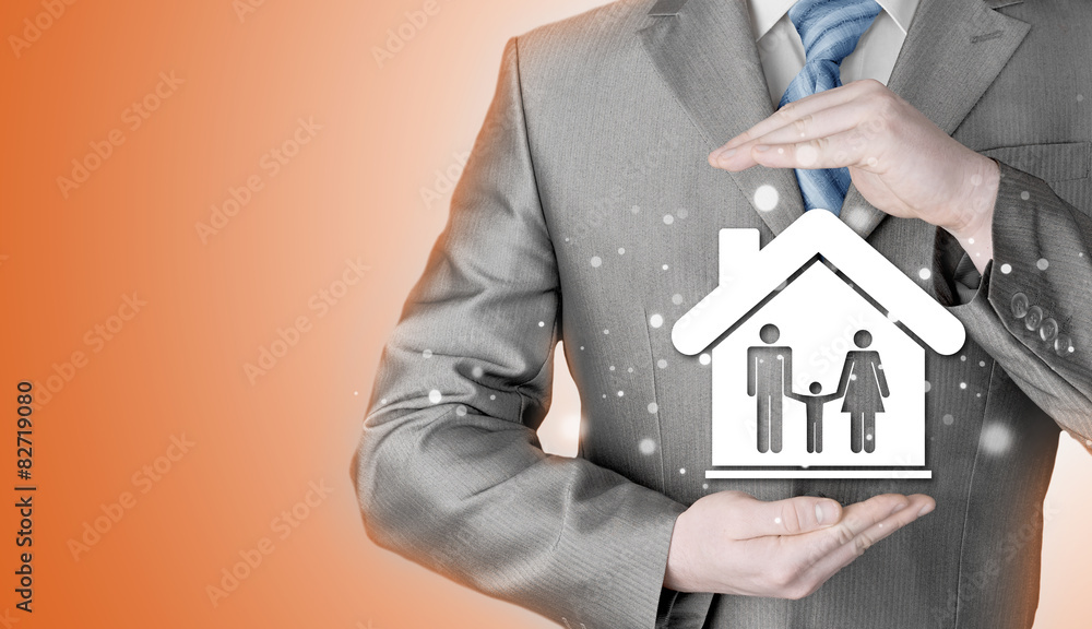 businessman protecting family in home with hands businessman protecting family in home with hands