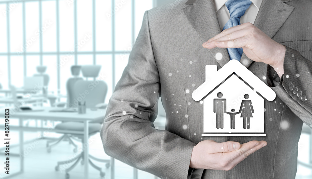 businessman protecting family in home with hands businessman protecting family in home with hands