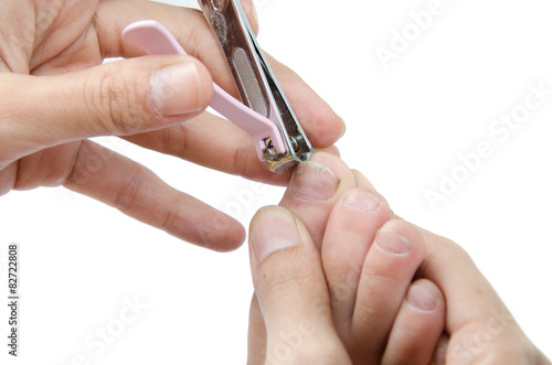 Mothor cutting kid s feet nail on white background