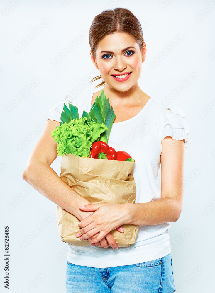 woman hold vegetables in grocery bag woman hold vegetables in grocery bag