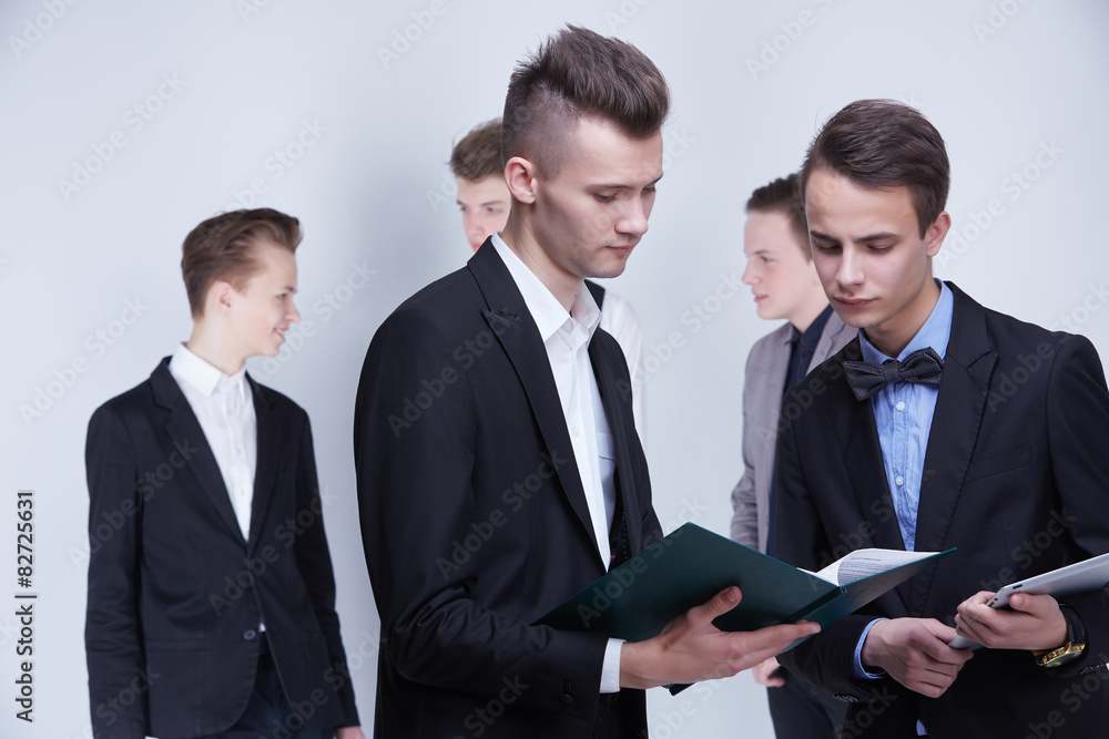 a group of young businessmen looking at paperwork a group of young businessmen looking at paperwork