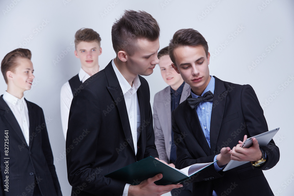a group of young businessmen looking at paperwork a group of young businessmen looking at paperwork