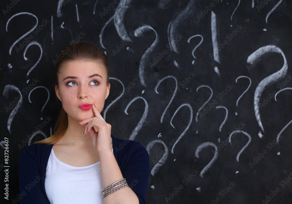 Young girl with question mark on a gray background Young girl with question mark on a gray background