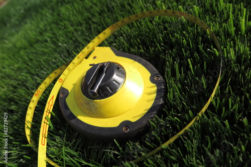 Measuring tape lying on the fresh mown lawn grass