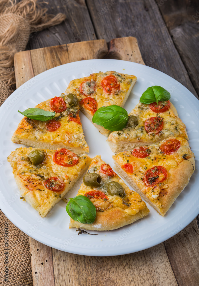 Homemade pizza with cheese and tomatoes on wooden table