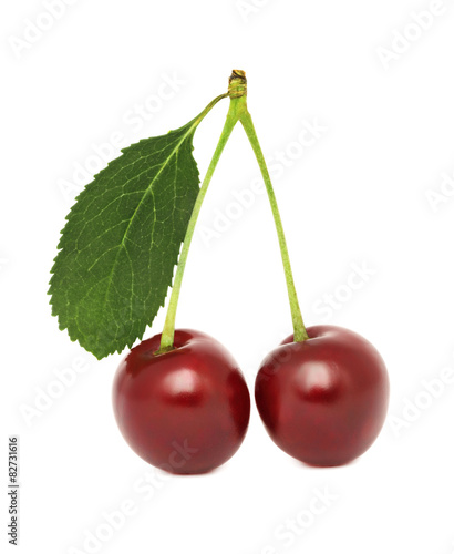 Two ripe cherry with green leaf  isolated 