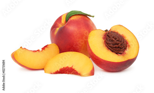 One whole and sliced nectarine with green leaf (isolated)