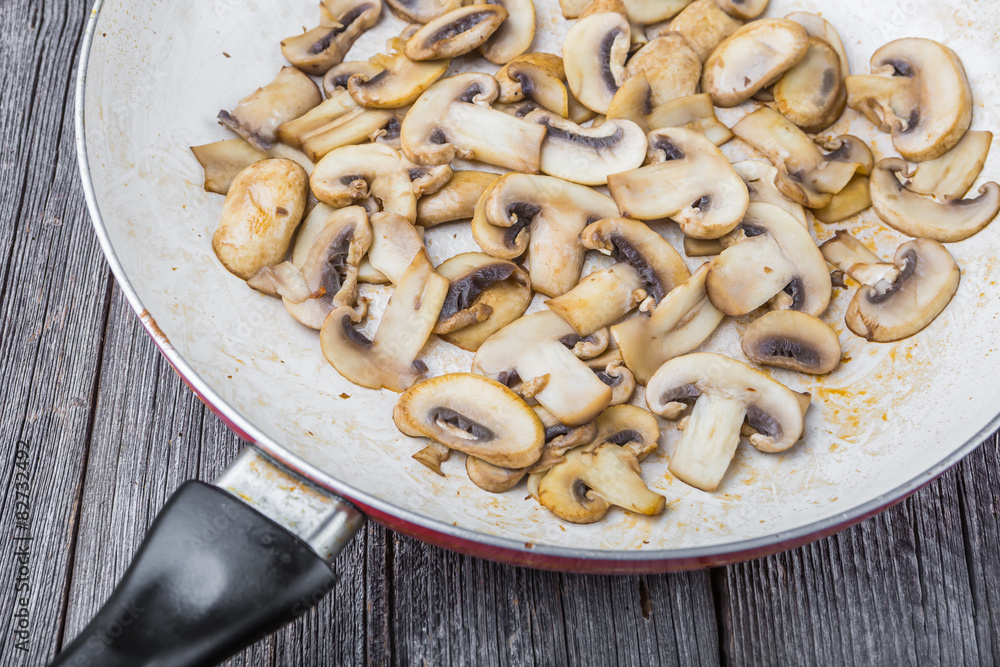 Butter fried sliced mushrooms in a pan.