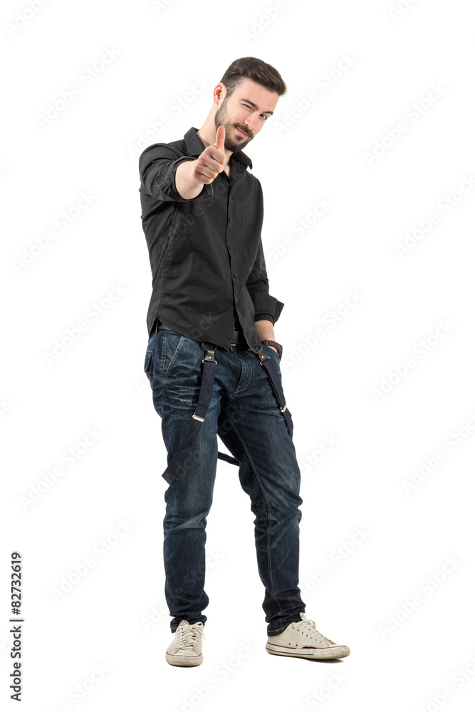 Winking friendly young man with thumb up gesture isolated Winking friendly young man with thumb up gesture isolated