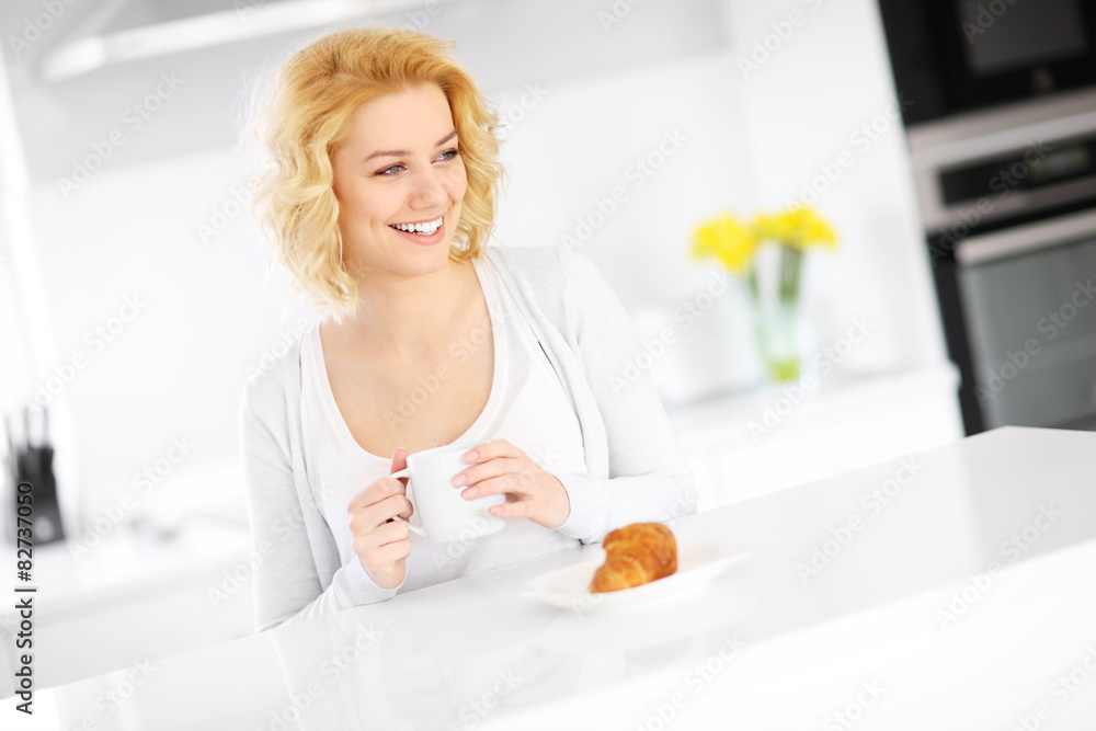 Young woman drinking coffee in the kitchen Young woman drinking coffee in the kitchen