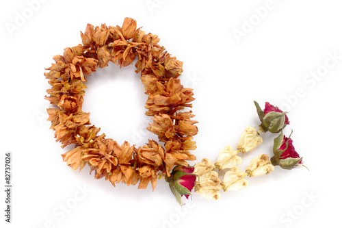 Obraz na plátne Brown dry garland with  red rose.