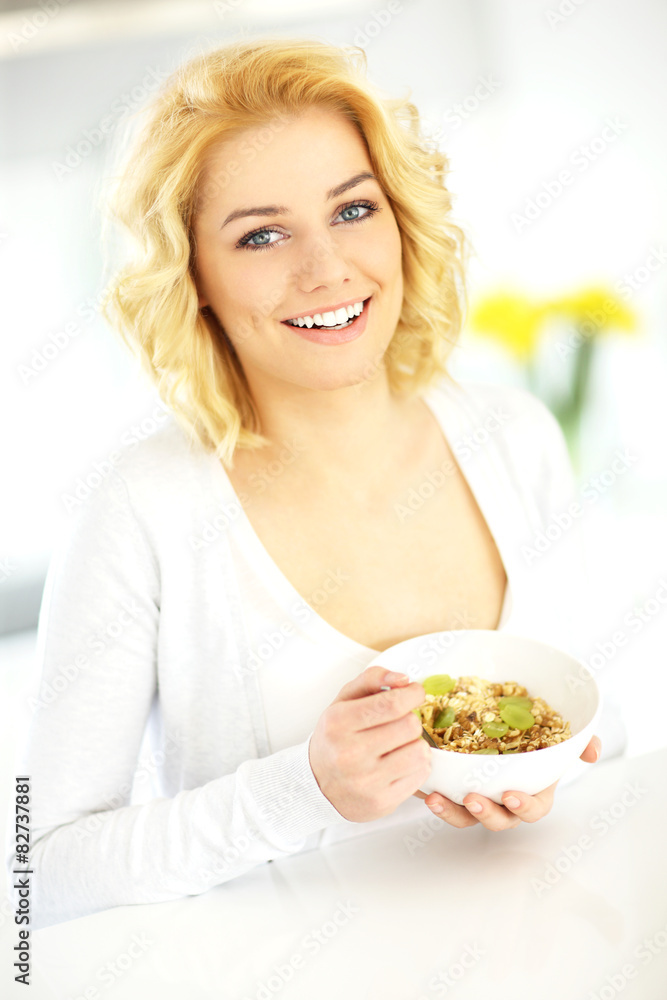 Young woman eating cereal in the kitchen Young woman eating cereal in the kitchen