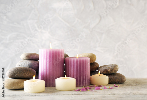 Still life with spa candles on light wallpaper background