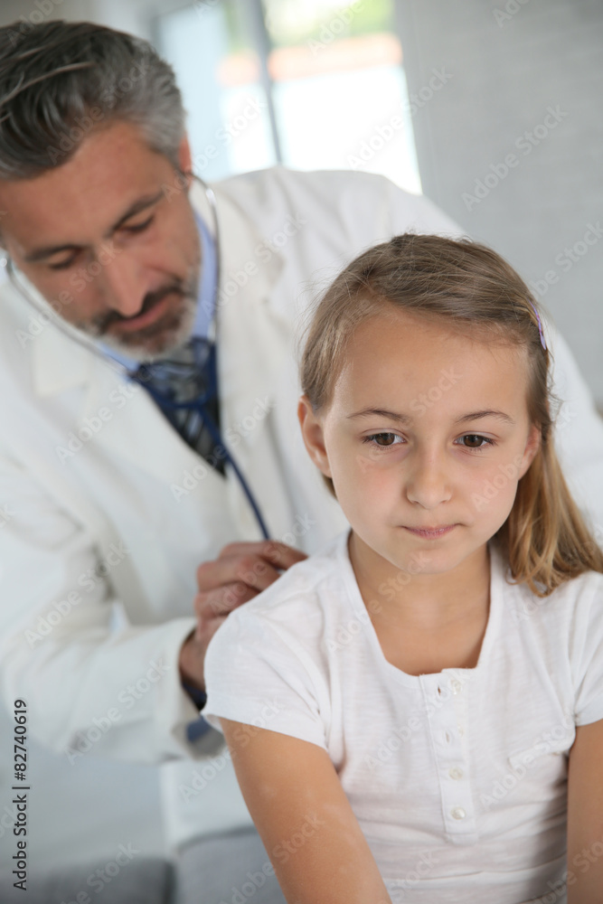 Doctor examining young girl with stethoscope Doctor examining young girl with stethoscope