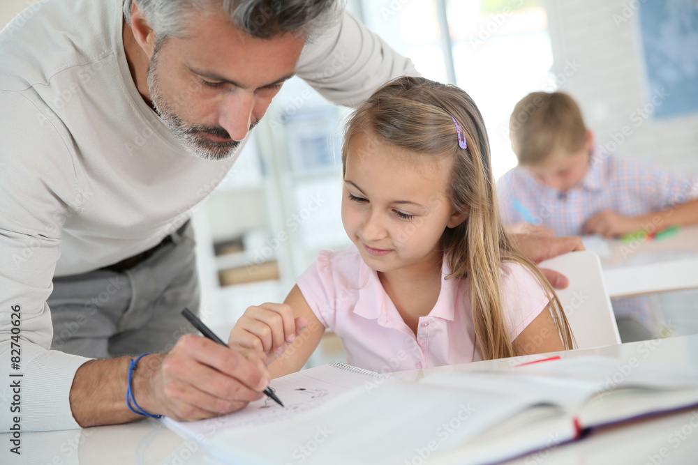 Obraz premium Teacher with schoolgirl in class