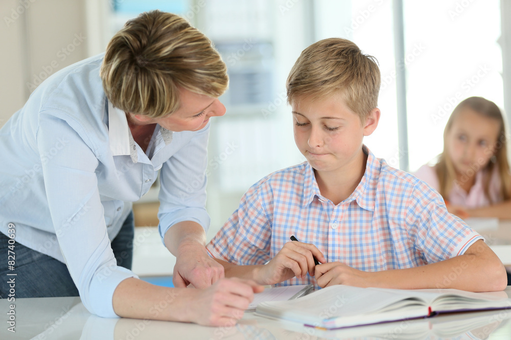 Teacher with schoolboy in classroom Teacher with schoolboy in classroom