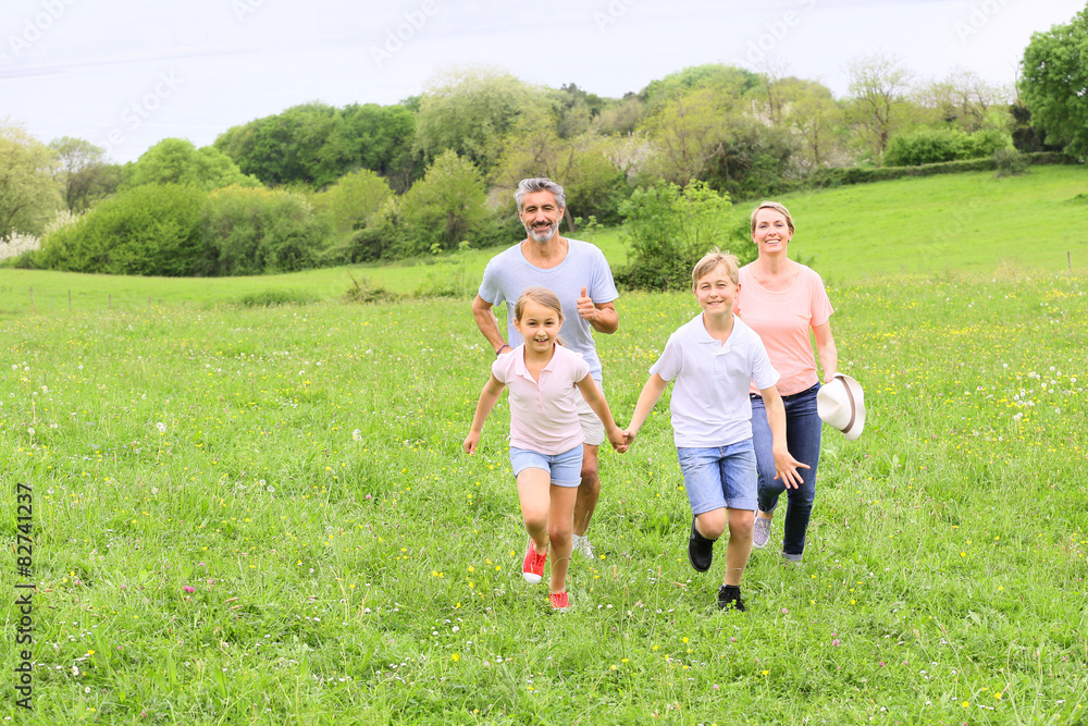 Family of four running in countryside