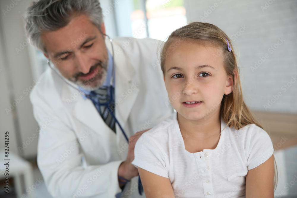 Doctor examining young girl with stethoscope Doctor examining young girl with stethoscope