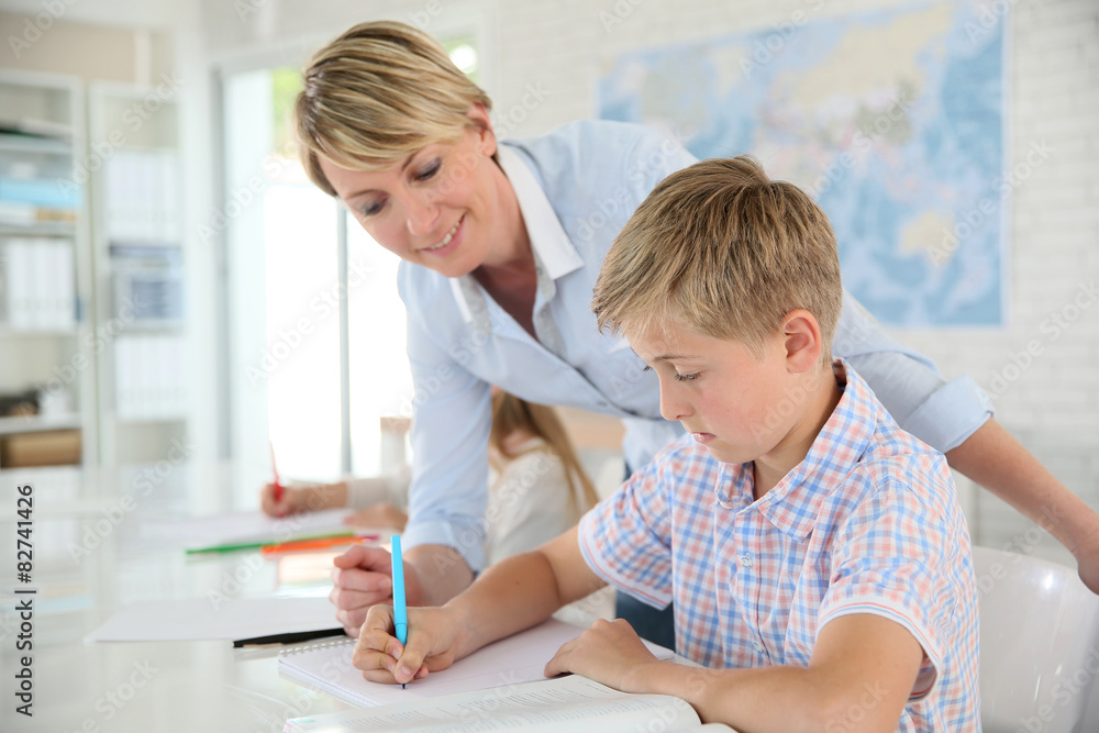 Fototapeta premium Teacher helping pupil with writing in class