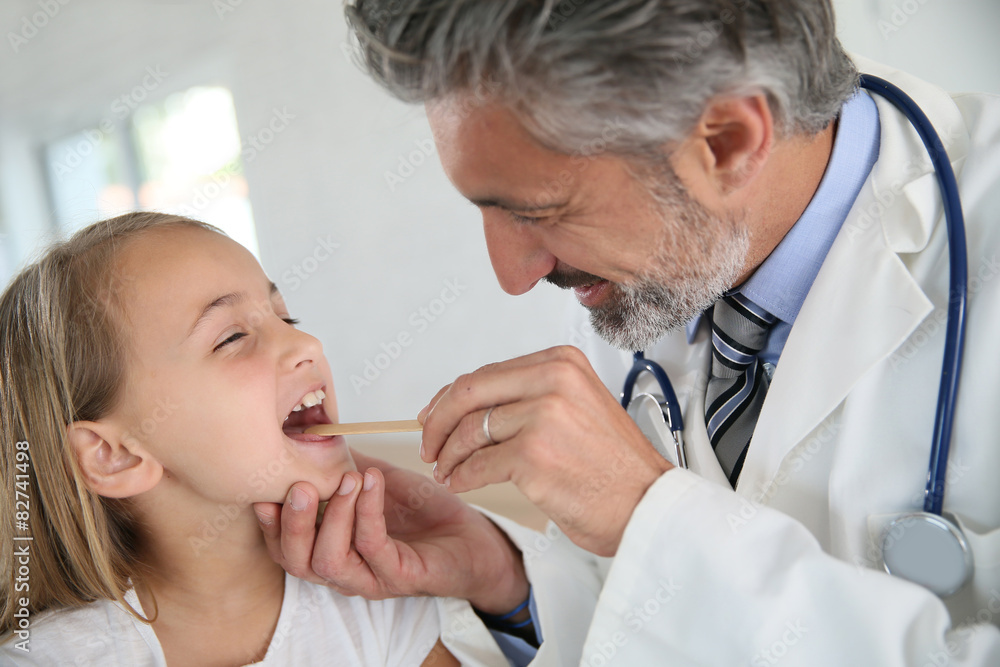 Doctor examining girl's throat