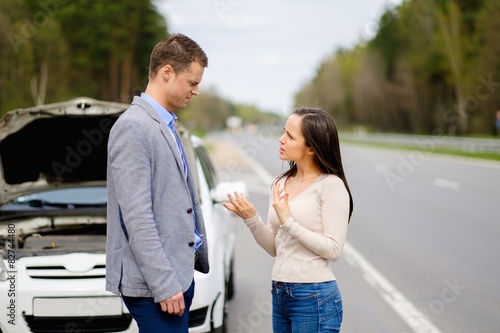 Canvas Print Couple near broken car on a highway roadside