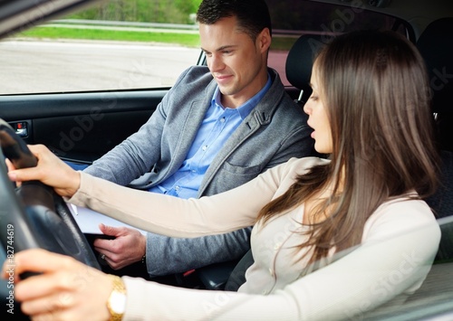 Driving instructor and woman student in examination car