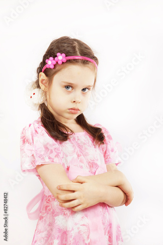 Little pretty girl wearing beautiful pink dress is angry
