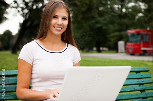 Woman using a laptop computer in a park