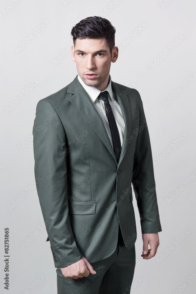 Fototapeta premium Businessman posing in a grey suit