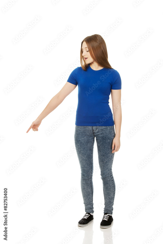 Shocked young woman pointing down. Shocked young woman pointing down.