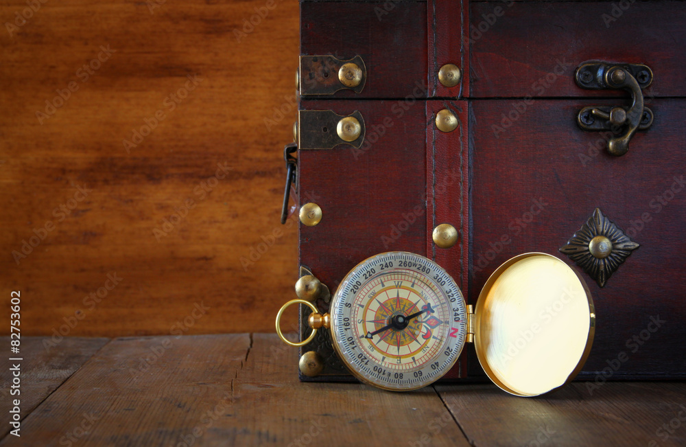 Fototapeta premium antique compass on wooden table 