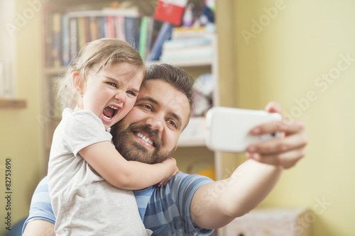 Young father with his cute little daughter taking selfie photo