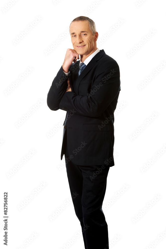 Happy mature businessman with hand under chin Happy mature businessman with hand under chin