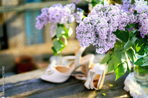 Bouquet of lilac on soft background with bride s shoes